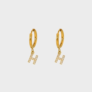 Close-up of gold-plated H-shaped earrings with sparkling pave-set white zirconia stones