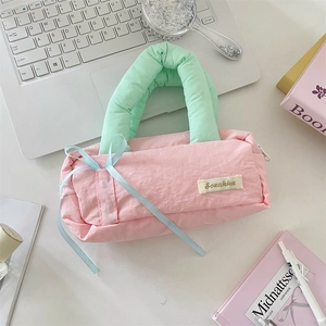 Macro detail of macaron puffy pencil case with ribbon bow and soft handle