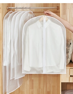 Detailed view of PEVA garment bags with zipper in a neat wooden closet setting