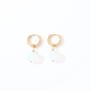 Close-up of geometric gold hoop earrings featuring square white translucent stone drops