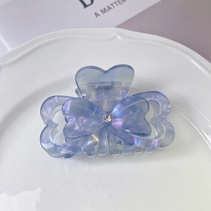 Detail of blue gradient butterfly hair claw clip with pearl finish and rhinestone center