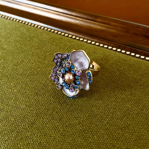 Macro shot of vintage floral ring with colorful rhinestones and pink enamel finish