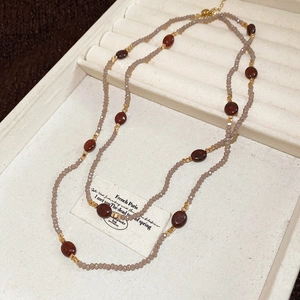 Détail d'un collier à deux rangs en œil de tigre avec perles facettées et accents dorés