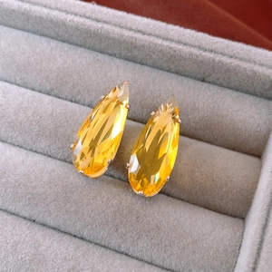 Detail shot of lemon yellow teardrop earrings with zircon in a jewelry box
