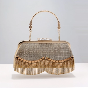 Detail of evening clutch featuring crystal fringes and ornate gold metal ring handle
