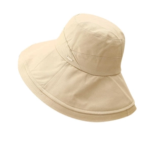 Detailed close-up of wide brim sun hat showing woven texture and oval metal emblem