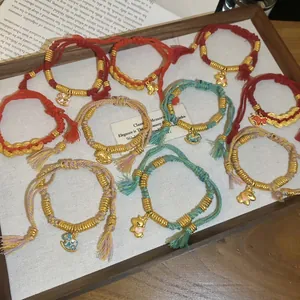 Handwoven red and green string bracelets with golden horse and rabbit charms