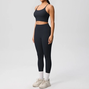 Detail of high-waist black yoga leggings and slim strap sports bra set on female model