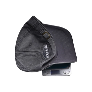 Detailed shot of vintage baseball cap on electronic scale showing weight of 84.8g