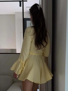 Detail view of the yellow A-line dress back with trumpet sleeves and adjustable ties