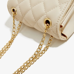 Detailed close-up of beige quilted PU leather crossbody bag with gold metal chain strap