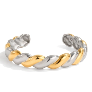 Detail of twisted 18K gold and silver stainless steel open bangle with cable texture