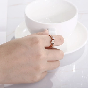 Detail of rose gold honeycomb heart ring with zircon inlay worn by model on finger