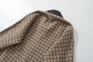 Makro-Detail der Hahnentritt-Jacke mit braunem Muster und grauem Rippenkragen