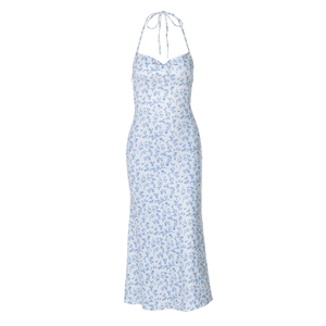 Flat lay of a floral halter dress with blue flower patterns on white fabric
