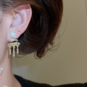 Macro view of Christmas tree spiral earrings with gold tassel and sparkling diamonds