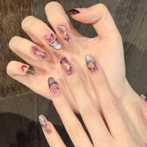 Détail macro d'ongles amande avec effet œil de chat violet et motifs de papillons