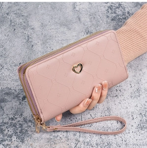 Pink long double-zipper wallet with diamond texture and gold heart charm on wristlet