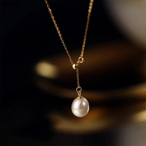 Detailed macro view of a high-luster oval freshwater pearl on a minimalist gold Y-necklace