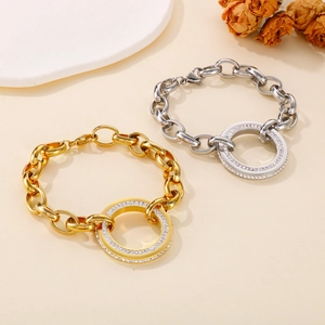 Detail of gold and silver thick chain bracelets with sparkling pavé round pendants on tray