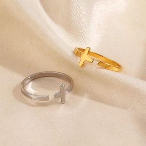 Minimalist stainless steel open cross rings in gold and silver finish on silk fabric
