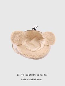 Detailed close-up of thickened beige sherpa fleece lining on children winter earflap hat