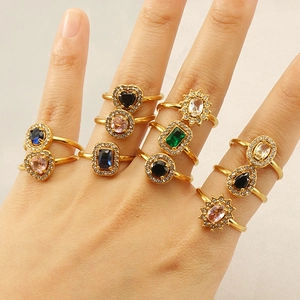 Close-up of layered gold zircon rings with colorful heart and teardrop gemstones