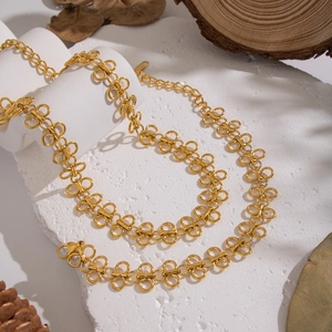 Gold double-loop chain necklace with butterfly link on elegant stone and wood display