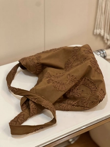 Detailed view of vintage brown suede tote with intricate 3D floral embroidery