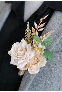 Detail view of a cream rose wedding boutonniere pinned to a grey suit lapel with twine wrap