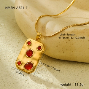 Macro shot showing dimensions of vintage gold necklace with red stones and hammered texture