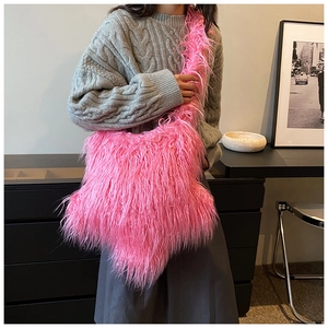 Close-up of bright pink fluffy plush shoulder bag showing soft fur texture and wide strap