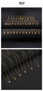 Detailed tile display of 26 gold stainless steel alphabet pendants on a black stand