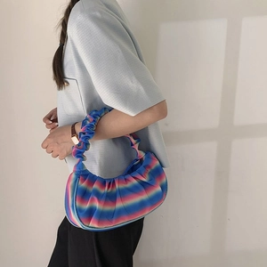Detail of colorful gradient pleated shoulder bag with soft textured handle and vibrant stripes
