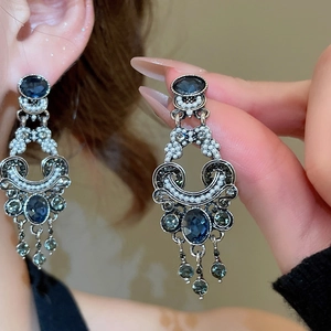 Detail view of vintage pearl tassel earrings with blue gemstone and silver needle