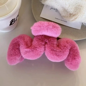 Nahaufnahme der rosa flauschigen Plüsch-Haarklammer mit elegantem Wellendesign auf Tisch