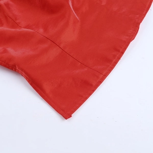 Gros plan détaillé du tissu en satin rouge brillant avec des coutures de qualité