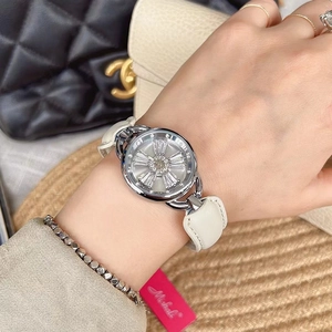 Detail of silver fashion watch with rotating crystal dial and white leather strap