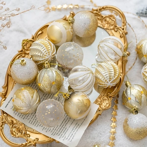Golden and white Christmas ball ornaments in glitter and matte finishes on a gold tray