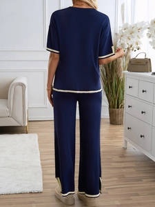 Detailed back view of dark blue knit set with contrast piping on top and trousers