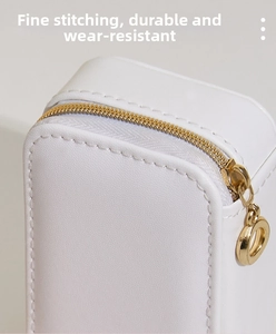 Macro shot of fine white faux leather texture and gold zipper detailing on jewelry box