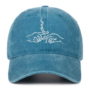 Close-up of white creative line art embroidery on washed blue cotton baseball cap