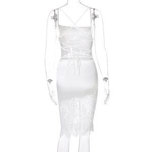 Détail de robe en satin blanc avec laçage au dos et bordure en dentelle fine sur l'ourlet