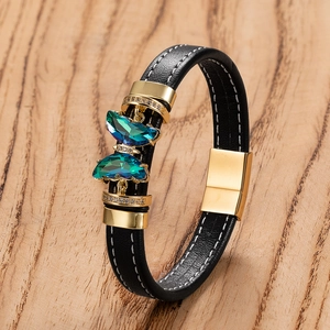 Bracelet en cuir tressé avec papillon doré et cristaux colorés sur bois naturel