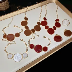Parure de bijoux vintage avec colliers, bracelets et bagues dorés en rouge et marron