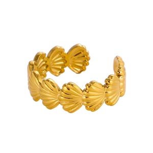 Macro shot of gold shell pattern open ring with polished metal texture on white background