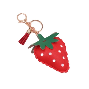 Red strawberry leather keychain with white dots, green leaves and a small tassel charm