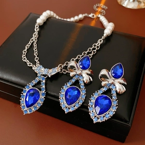 Detail of vintage silver necklace and blue gemstone earrings set with pearl chain