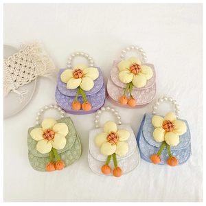 Flat lay of five colorful children bags with pearl handles and large yellow flower detail