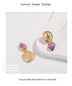 Detail showing elegant purple crushed shell inlay on minimalist golden drop earrings